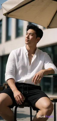 Asian man with light-medium skin, black short hair styled with volume on top and sides swept back, c