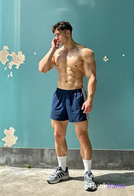 Shirtless, broad shoulders, defined pectorals, ripped abs, thick thighs visible;