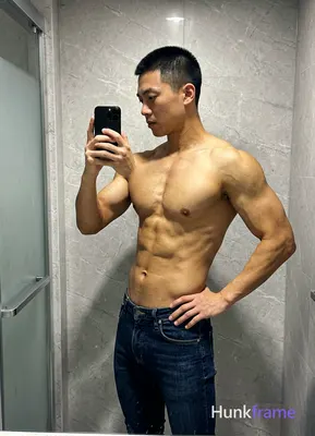 Asian man with short black buzz cut and clean-shaven face, standing sideways facing left in a candid