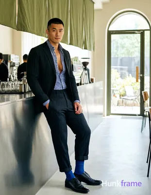 an anonymous figure man standing casually leaning against coffee bar counter in modern cafe interior