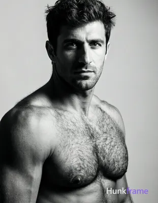 Caucasian man with short dark tousled hair, clean-shaven face, direct gaze and n