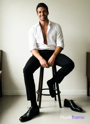 White button-down shirt sleeves rolled to elbows, top buttons undone revealing bare chest from colla