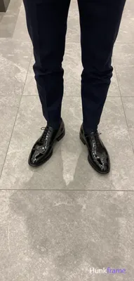 Top-down fashion editorial crop focusing on luxury footwear and tailored trouser