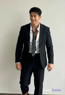 Asian man with short dark black hair side parted left, clean-shaven face smiling while looking off-c