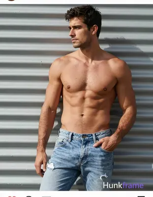 A handsome adult man with medium-tan skin and short dark hair stands leaning aga
