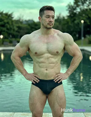 German man with fair skin and a strong brow ridge, shirtless, standing near a se