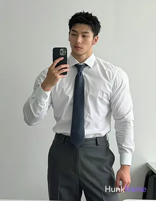 an anonymous figure man with short spiky black hair and light stubble stands in a mirror selfie, hol