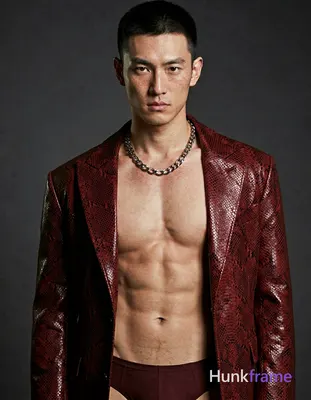 A handsome white man with fair freckled skin and short dark cropped hair stands head-and-shoulders c