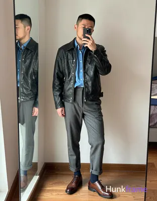 Asian man with short black buzz cut and light stubble stands casually in a modern apartment bedroom,
