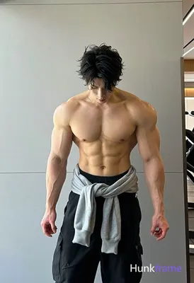 Asian man with light tan skin and short dark tousled hair stands upright in an i