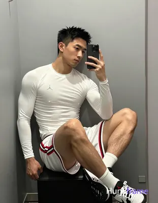 Asian man with light-medium skin and short black textured spiky hair, clean-shaven face in mirror se