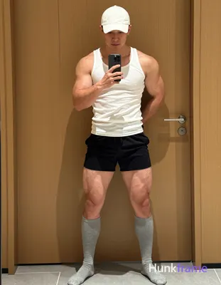 Candid iPhone selfie of a handsome muscular man with light-medium skin and short dark hair under a w