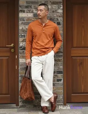 Asian man with short buzz cut and minor chin stubble stands in relaxed contrapposto, weight on right