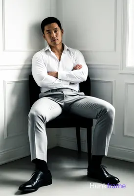 Asian man with short black hair and clean-shaven face, neutral direct gaze seated in a minimalist co