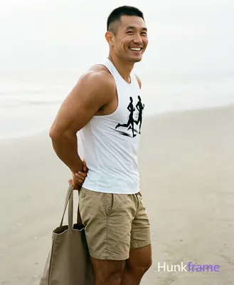 Asian man with short buzz cut and clean-shaven jaw, smiling broadly looking over left shoulder; Stan