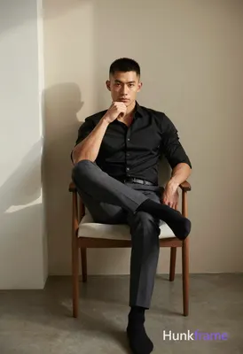 An athletic adult man with short black hair and clean-shaven face sits centered 