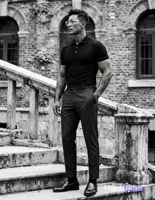 Adult man in profile facing left, standing on stone steps beside a railing with 