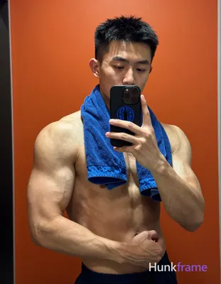Asian man with light to medium tan skin and short black hair stands facing a mir