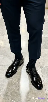 Top-down fashion editorial crop focusing on luxury footwear and tailored trouser