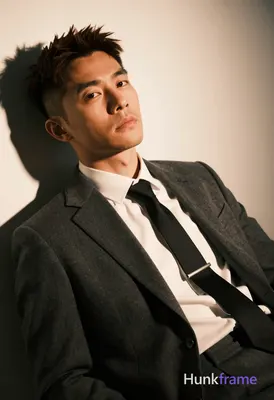 Asian man with short dark brown hair in an undercut style and clean-shaven face 