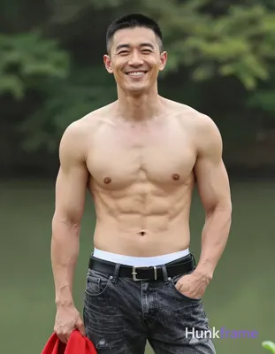Asian man with short black buzz cut and clean-shaven face, smiling broadly with slight head tilt to 