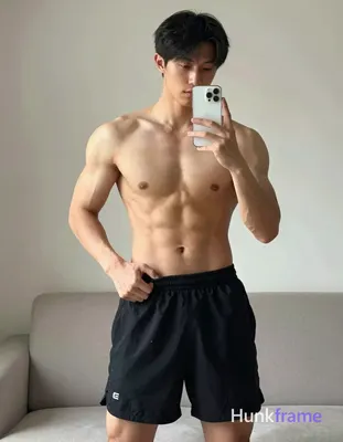 Asian man with light to medium tan skin and short straight black hair stands shirtless in a vertical