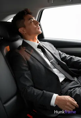 Asian man with short dark brown hair and undercut style reclining diagonally in 