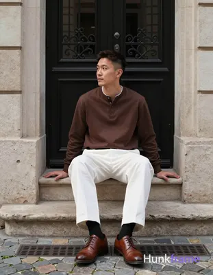 Asian man with light-medium skin and short dark brown undercut hair sits centere