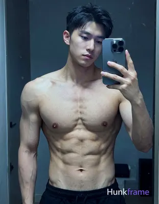 A handsome masculine man standing with a slight lean forward, shirtless, with de