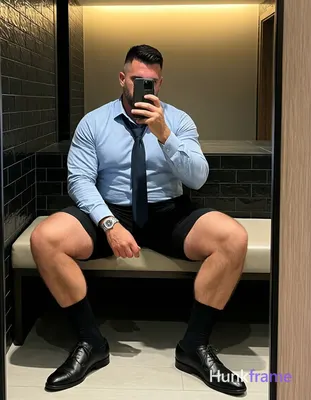 Adult man with short black hair and fade sides seated on a light bench, legs spr