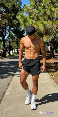 A handsome medium-dark skinned man with dark short hair under a backward black c