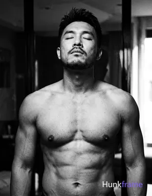 An Asian man with medium-dark skin and a dark, short hairstyle styled upward sta