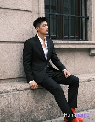 Asian man, short black textured hair spiky on top tapered sides clean-shaven neutral contemplative g