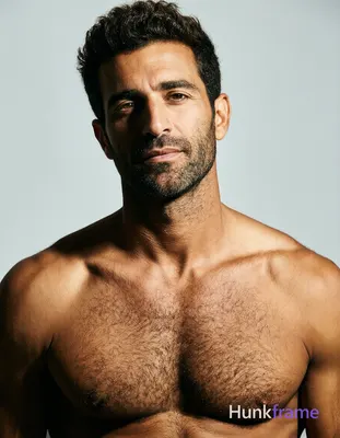 A handsome adult man with light to medium skin, dark brown short textured hair styled upward, and sh