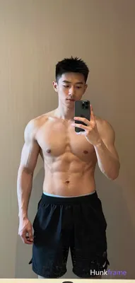 Asian muscular man with short black hair and clean-shaven face stands centered i