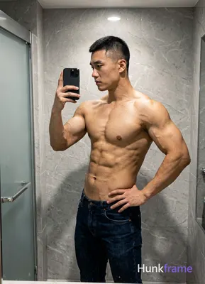 Asian man with short black buzz cut and clean-shaven face, standing sideways facing left in a high-r