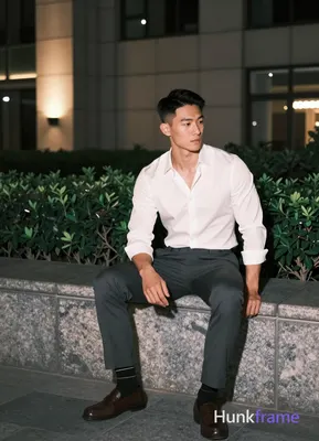 Asian man with short black straight side-parted hair and clean-shaven face, neutral pensive gaze loo