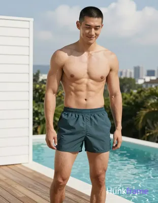 Asian man with short black buzz cut and clean-shaven face, light tan skin smiling gently while looki