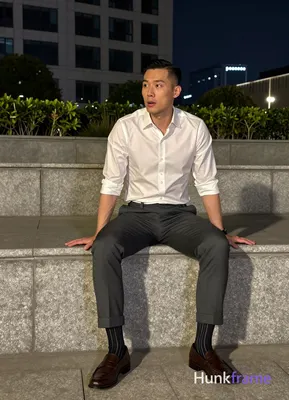 Asian man with short black side-parted slick-back hair and clean-shaven face, neutral to slightly su