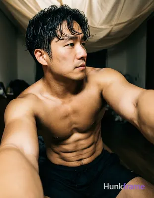 Asian man with short dark black slightly wavy wet-looking hair parted left, clean-shaven face neutra