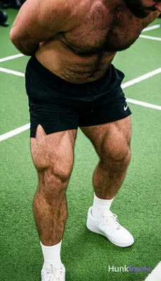 High-angle muscle bear close-up on lower body of shirtless man with thick thighs and defined quadric