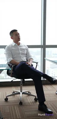 an anonymous figure man in his 30s with a short black buzz cut and clean-shaven face, gazing upward 