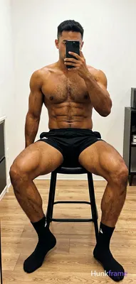 A candid vertical lifestyle shot of a dark-skinned adult man taking a mirror sel