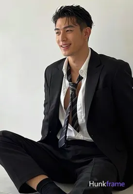 Asian man with short dark black hair side parted left, clean-shaven face smiling while looking off-c