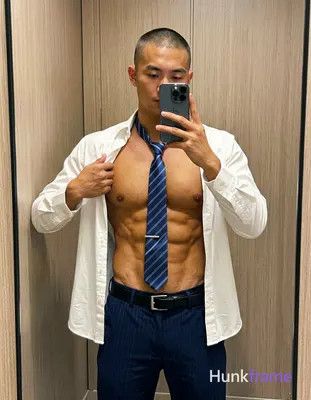 Adult man with light to medium tan skin and buzz cut stands in front of a mirror taking an iPhone se