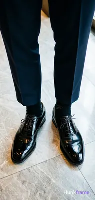 Top-down fashion editorial crop focusing on luxury footwear and tailored trouser