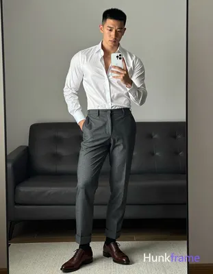 Asian man standing in front of full-length mirror holding white smartphone at ch