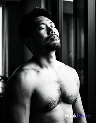 An Asian man with medium-dark skin and a dark, short hairstyle styled upward sta