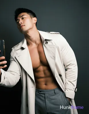 A single Asian man standing with his torso slightly leaned forward and head tilted upwards, showcasi