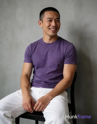 Asian man with short buzz cut and clean-shaven face smiling, seated upright on a